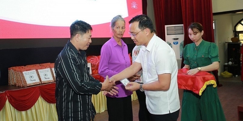 Ông Nguyễn Tiến Thiết - Chủ tịch UBND huyện Ứng Hòa, trao tặng thẻ bảo hiểm y tế cho hộ có hoàn cảnh khó khăn.